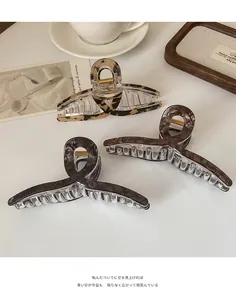 Trois grandes pinces à cheveux à motif écaille et léopard sur un plateau décoratif