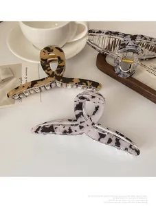 Gros plan de grandes pinces à cheveux en acétate aux motifs marbre et léopard élégants