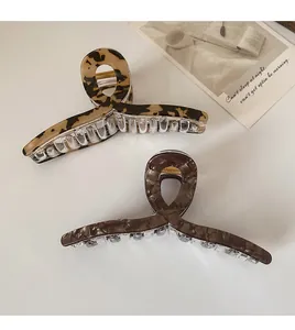 Gros plan de pinces à cheveux aux motifs léopard écaille et marbre sur fond blanc