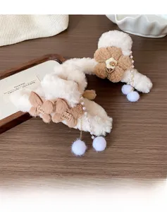 Détail de pinces à cheveux en peluche avec pampilles de perles et texture en fausse fourrure