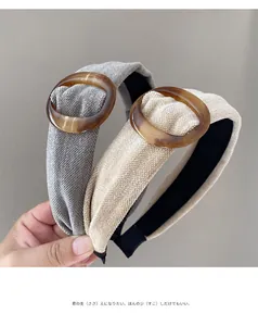 Detail van brede retro haarbanden in grijs en beige met amberkleurige harsringen
