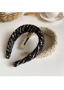 Detail of handmade black and beige tweed headbands with golden sequins and woven labels