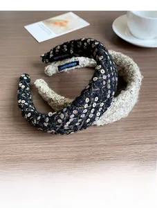 Detail of sequined tweed headbands in black and cream with handmade interior labels