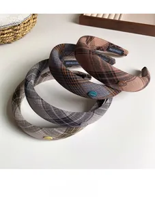 Detail of vintage plaid headband texture with handmade label and metal logo detail