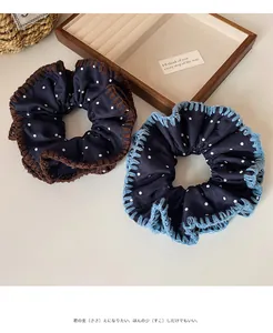Detail of navy blue polka dot scrunchies with crochet edges on a wooden tray