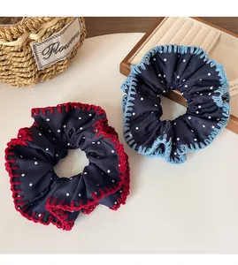 Close-up of navy blue polka dot scrunchies with red and blue contrast stitching