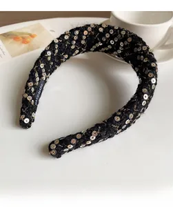 Detail of handmade black woven headband with gold threads and silver sequins