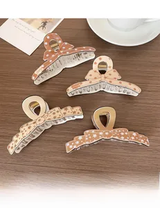 Détail de pinces à cheveux nœuds marron avec motifs à pois sur une surface en bois