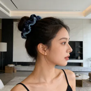 Blue denim scrunchie with white polka dots worn by a model in a high-quality lifestyle shot