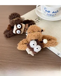 Détail de pinces à cheveux en peluche marron et kaki avec décorations d'yeux mignons