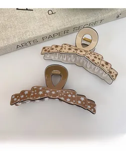 Détail de pinces à cheveux nœud marron avec motifs d'étoiles et bords ondulés