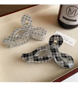 Dettaglio di fermagli per capelli a fiocco con motivo plaid e glitter fini