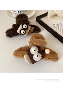 Gros plan de pinces à cheveux en peluche bouclée avec yeux de dessin animé en marron