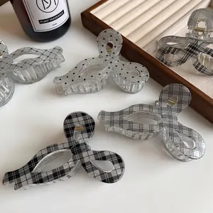 Eleganti mollette per capelli a fiocco con glitter, pois e motivi scozzesi sul tavolo