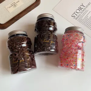 Three-pack wide elastic hair bands in clear jars with gold lettering and silver lids