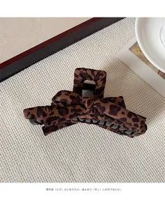Detail of leopard print velvet bow claw clip with fuzzy texture and vintage aesthetic