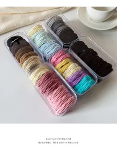 Close-up of high-elastic kids' hair ties set in clear storage boxes on cozy background