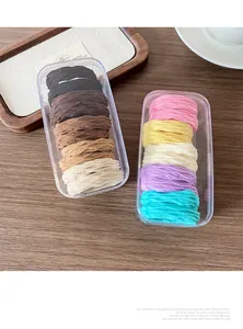 Detail of colorful elastic hair ties with pleated texture in a clear storage box