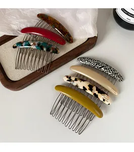 Detail of 10-tooth metal hair combs with colorful acetate patterns and gold handmade text