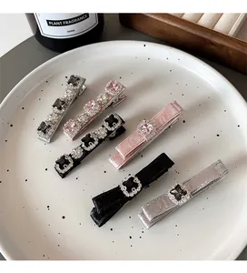 Close-up of sparkling rhinestone hair clips and velvet ribbon clips on ceramic tray