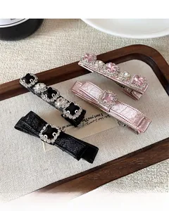 Close-up of elegant bow and gemstone hair clips set on a vintage wooden tray