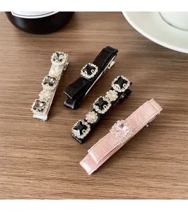 Detailed view of satin ribbon hair clips with sparkling crystal and diamond accents
