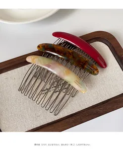 Detailed view of three French handmade hair combs in tortoise shell and red patterns