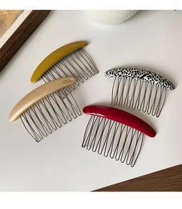 Detail of four colorful hair side combs with smooth resin tops and 11 fine metal teeth