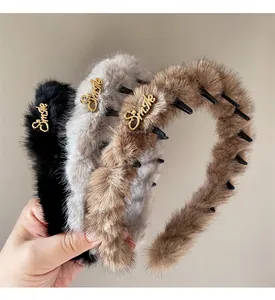 Dettaglio di cerchietti in peluche leopardo nero, grigio e marrone con decoro Smile
