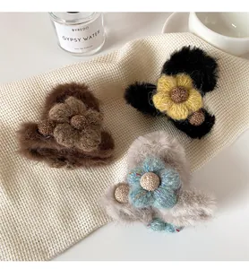 Detail van pluchen haarklemmen met gebreide bloemen in warme herfstkleuren
