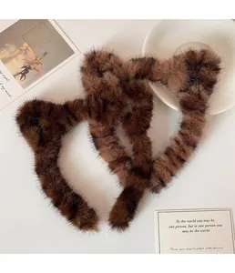 Détail de serre-têtes oreilles de chat en peluche avec motif léopard marron doux