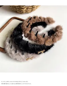 Dettaglio di cerchietti in peluche con denti antiscivolo e ciondoli Smile in metallo