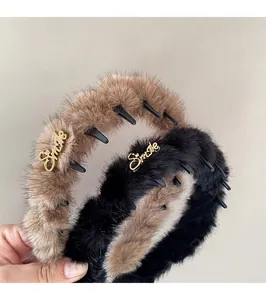 Dettaglio di cerchietti in peluche con denti antiscivolo e decoro Smile dorato