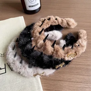 Tre cerchietti in peluche marrone, nero e beige con dettaglio logo dorato