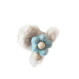 Grijze pluche haarklem met blauwe gebreide bloem voor dames winterse haarstyling