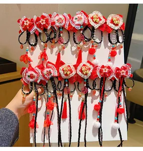 Detail of Chinese New Year hair clips with red bows, faux fur, and long tassels for girls