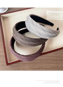 Lot de trois serre-têtes en tissu à chevrons gris, marron et rouge sur un plateau