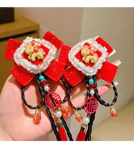 Detail of red velvet bow hair clips with Fu character pendants and long tassels