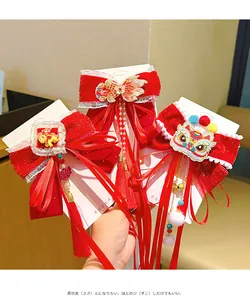 Detail of red velvet hair bow with traditional embroidery, tassels and pearl accents