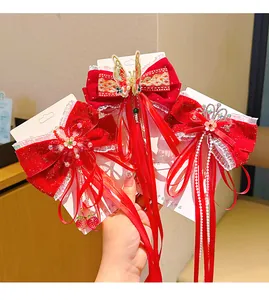 Detail of red velvet Chinese New Year hair bows with gold embroidery and pearl tassels
