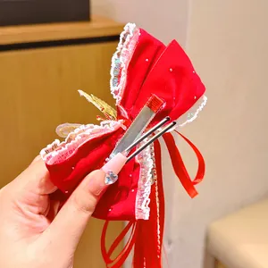 Red velvet bow hair clip with lace trim and long ribbon tassels for girls' festive styling