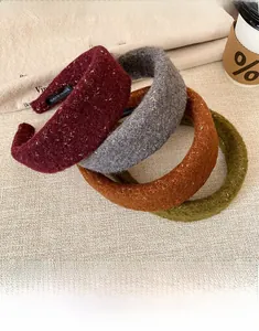 Close-up of sparkling sequin tweed headbands in burgundy, grey, caramel, and moss green