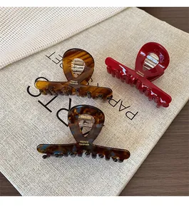 Detailed view of acetate claw clips with gold France Handmade logo on fabric