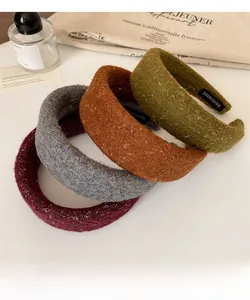 Detail of four colorful sequined wool headbands featuring handmade labels and soft textures
