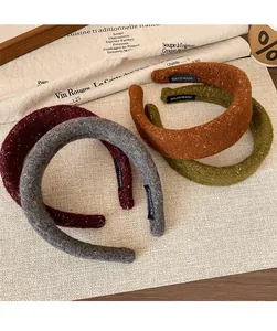 Detail of four colorful tweed headbands with gold sequins and handmade labels