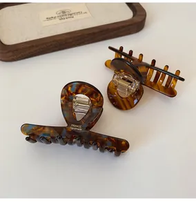 Close-up of tortoise shell acetate hair claws with gold France Handmade logo