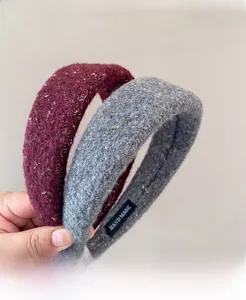 Detail view of handmade tweed headbands in burgundy and grey with gold thread texture