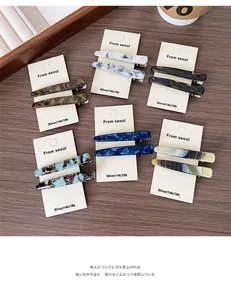 Détail de barrettes à cheveux en acétate écaille de tortue sur une carte de support