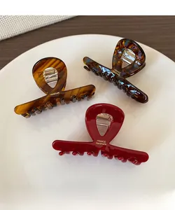 Detailed macro view of handmade acetate hair claws with premium metal spring and golden logo