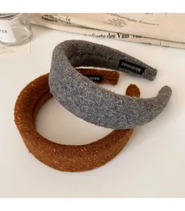 Detail of wool-like headbands with gold glitter and handmade labels in grey and brown